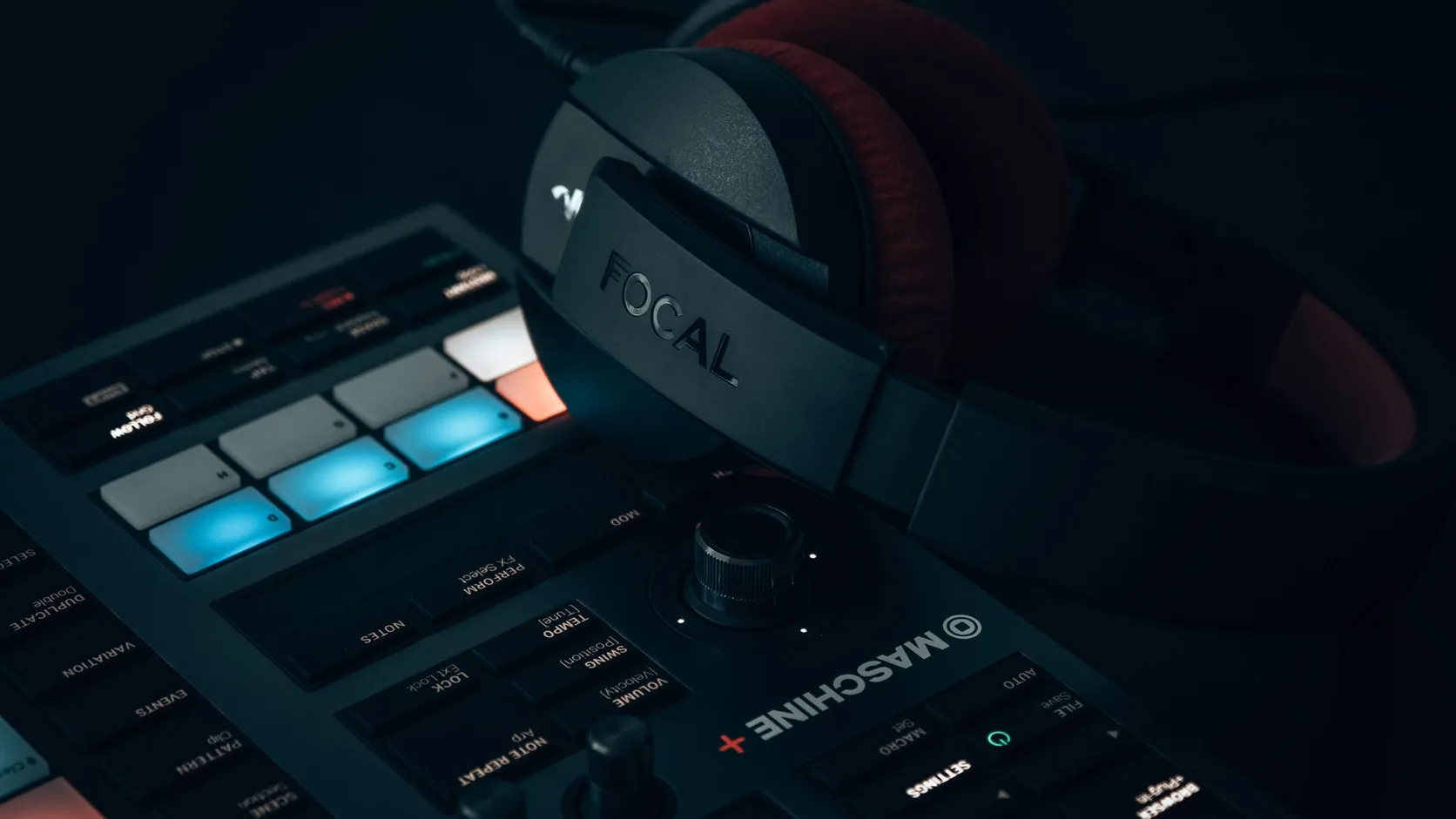 Drum machine and headphones on a studio desk
